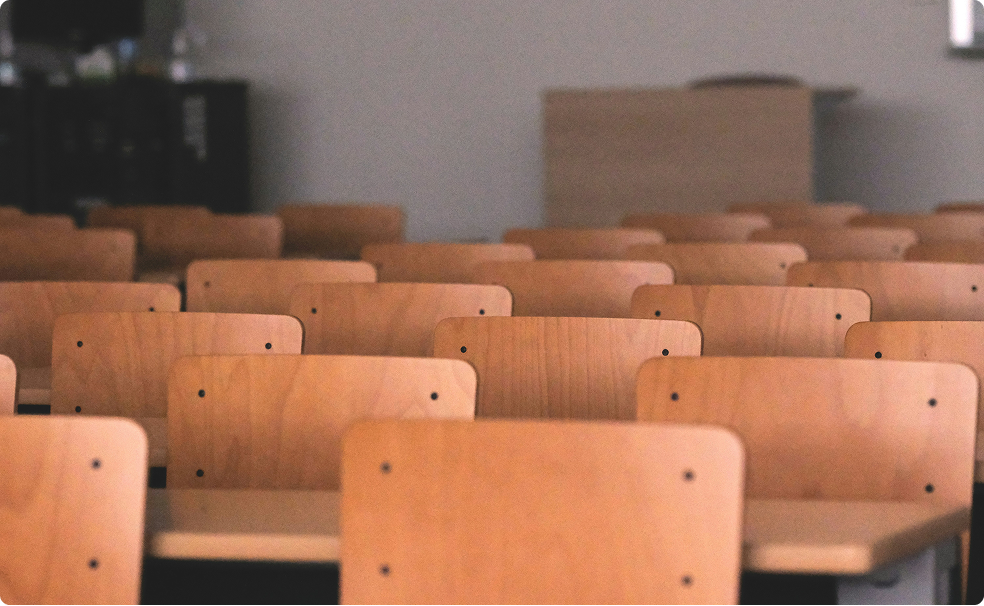 Photo of rows of school desk chairs in a classroom